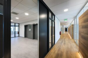 Moderne kantoorhal met liften, glazen wanden en houten vloeren aan de Prof. W.H. Keesomlaan.